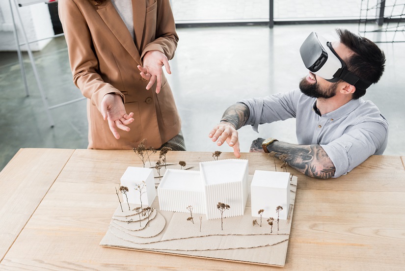 virtual reality architect in virtual reality headset talking with colleague